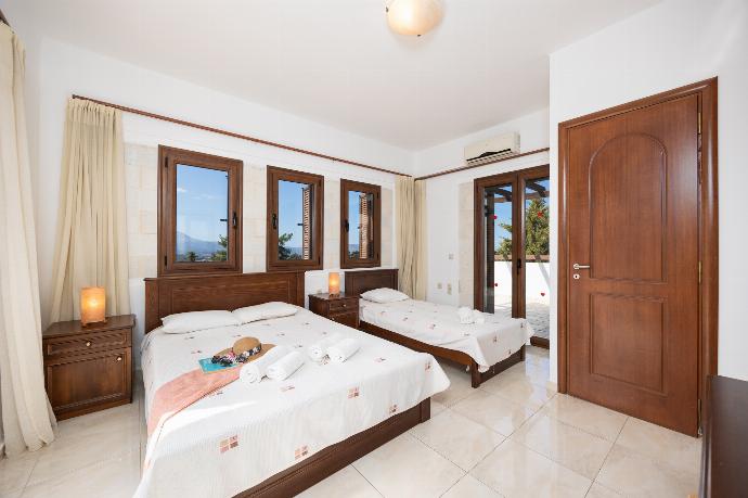 Bedroom with double bed, single bed, en suite bathroom, and A/C . - Villa Nikolas . (Photo Gallery) }}