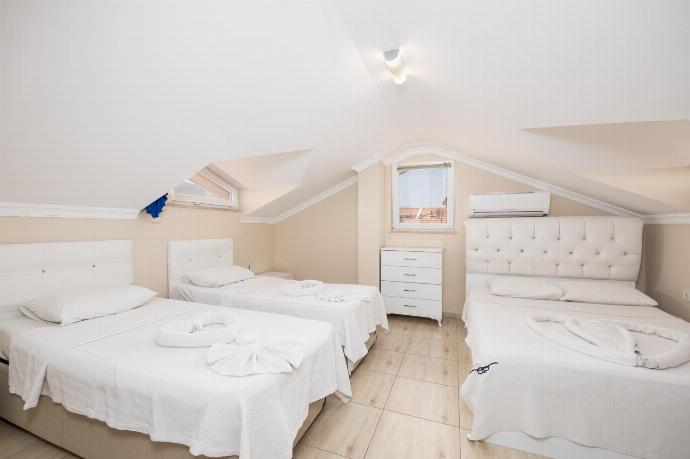 Bedroom with double bed and two single beds, en suite bathroom, and A/C . - Villa Heyday . (Photo Gallery) }}