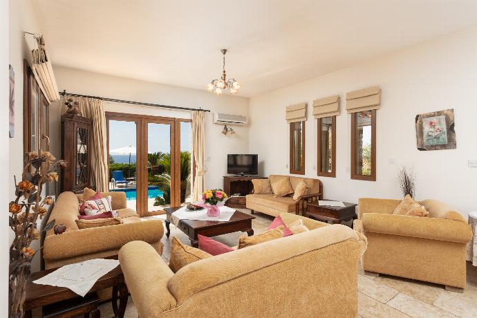 Open-plan living room on ground floor with sofas, dining area, kitchen, ornamental fireplace, A/C, WiFi internet, satellite TV, and sea views . - Villa Erato . (Photo Gallery) }}