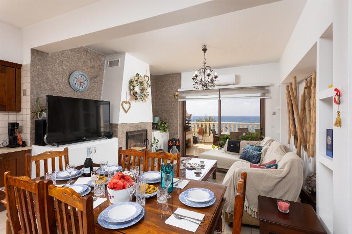 Main building: open-plan living room with sofas, dining area, kitchen, ornamental fireplace, A/C, WiFi internet, satellite TV, and sea views . - Villa Beach Heaven . (Photo Gallery) }}