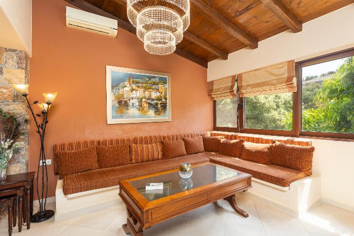 Open-plan living room with sofas, dining area, kitchen, ornamental fireplace, A/C, WiFi internet, and satellite TV . - Villa Elounda Blue . (Photo Gallery) }}