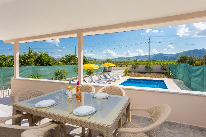 Outdoor sheltered terrace with dining area . - Villa Corals . (Photo Gallery) }}