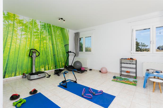 Living area with sofa, gym area, kitchen, and satellite TV . - Villa Sonata . (Photo Gallery) }}