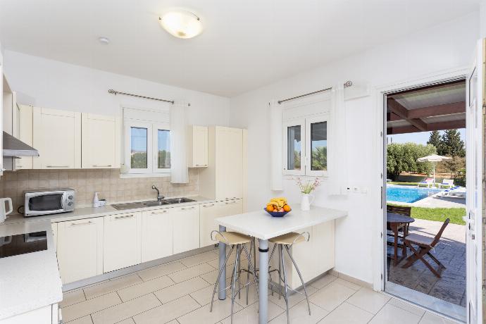 Equipped kitchen with dining area and terrace access . - Amphitrite Villa . (Photo Gallery) }}