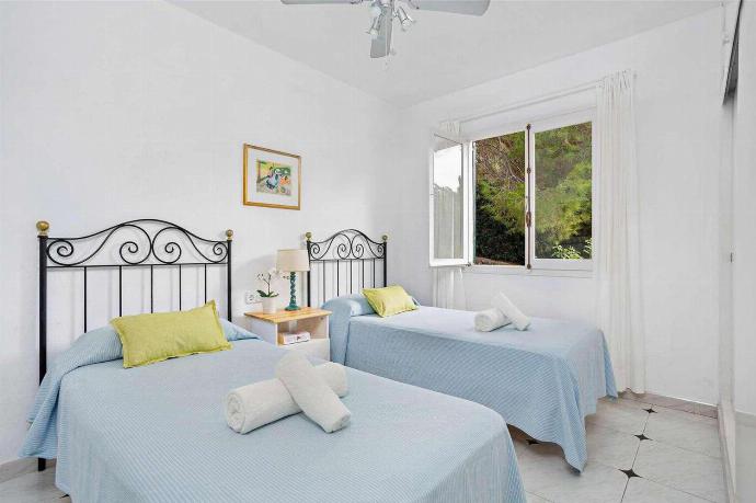 Twin  bedroom with a fan . - Villa Binilisa . (Photo Gallery) }}