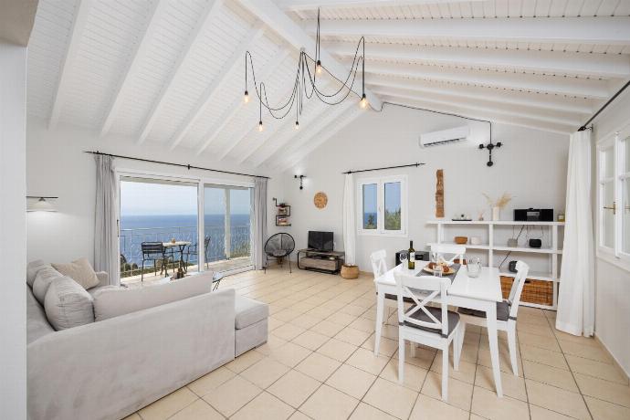 Open-plan living room with sofa, dining area, kitchen, A/C, WiFi internet, satellite TV, and sea views . - Villa Bougainvillea . (Photo Gallery) }}