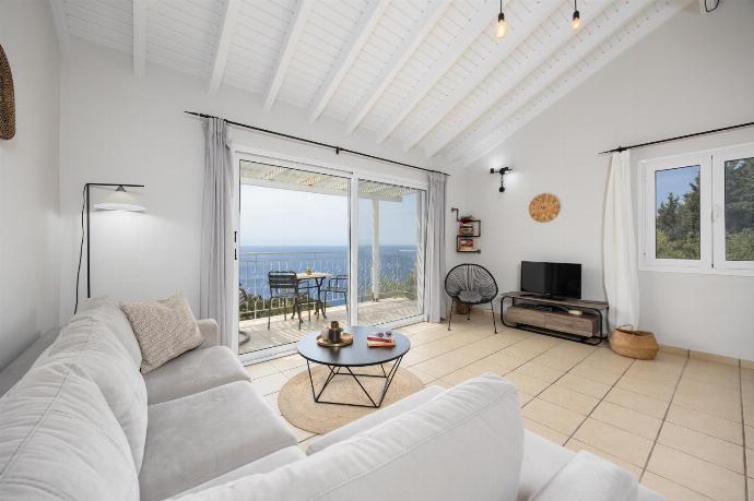 Open-plan living room with sofa, dining area, kitchen, A/C, WiFi internet, satellite TV, and sea views . - Villa Bougainvillea . (Photo Gallery) }}