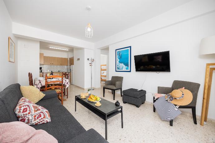 Open-plan living room with sofa, dining area, kitchen, A/C, WiFi internet, and satellite TV . - Bluesea View Latchi Apartment . (Fotogalerie) }}