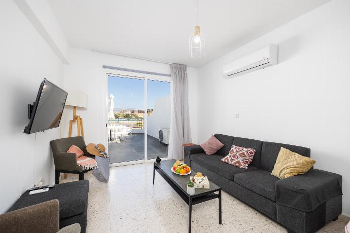 Open-plan living room with sofa, dining area, kitchen, A/C, WiFi internet, and satellite TV . - Bluesea View Latchi Apartment . (Fotogalerie) }}