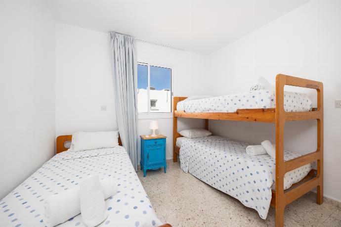 Bedroom with single bed, bunk bed, and A/C . - Bluesea View Latchi Apartment . (Photo Gallery) }}