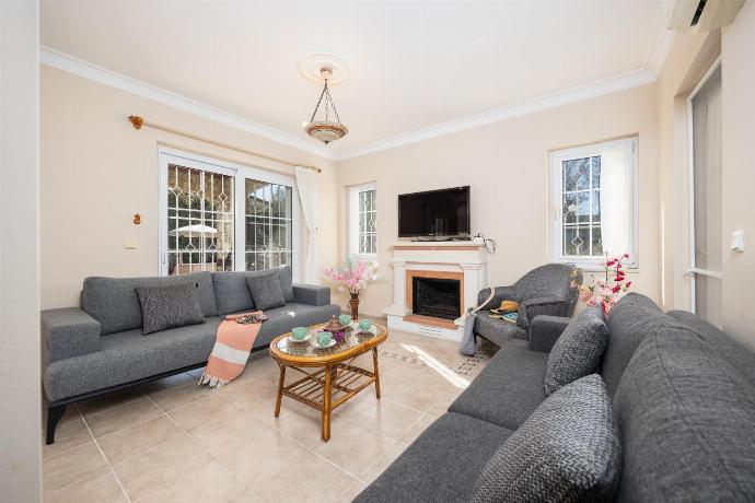 Open-plan living room with sofas, dining area, kitchen, ornamental fireplace, A/C, WiFi internet, and satellite TV . - Villa Begonvil . (Fotogalerie) }}