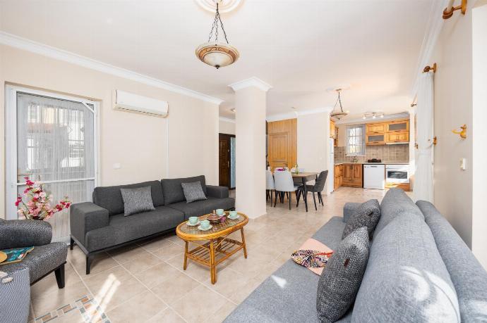 Open-plan living room with sofas, dining area, kitchen, ornamental fireplace, A/C, WiFi internet, and satellite TV . - Villa Begonvil . (Fotogalerie) }}