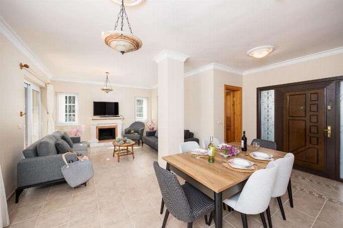 Open-plan living room with sofas, dining area, kitchen, ornamental fireplace, A/C, WiFi internet, and satellite TV . - Villa Begonvil . (Fotogalerie) }}