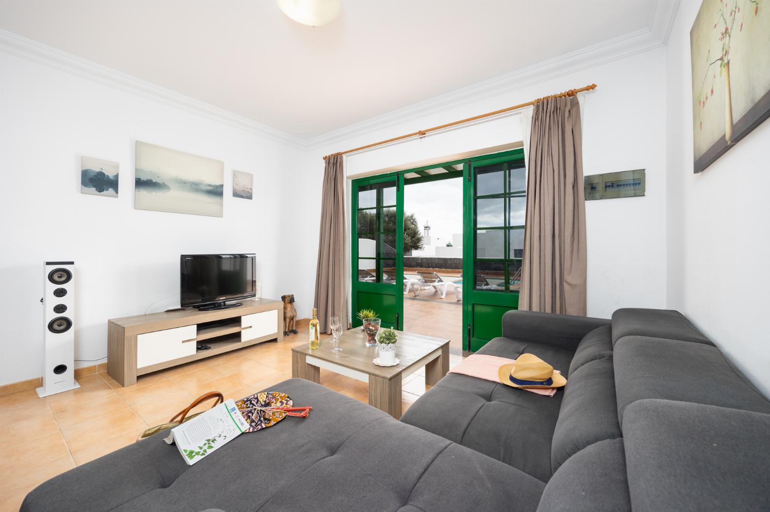 Living room with sofa, dining area, A/C, WiFi internet, and satellite TV