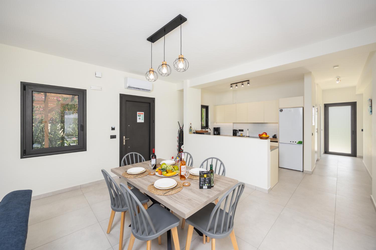 Open-plan living room with sofa, dining area, kitchen, ornamental fireplace, A/C, WiFi internet, and satellite TV