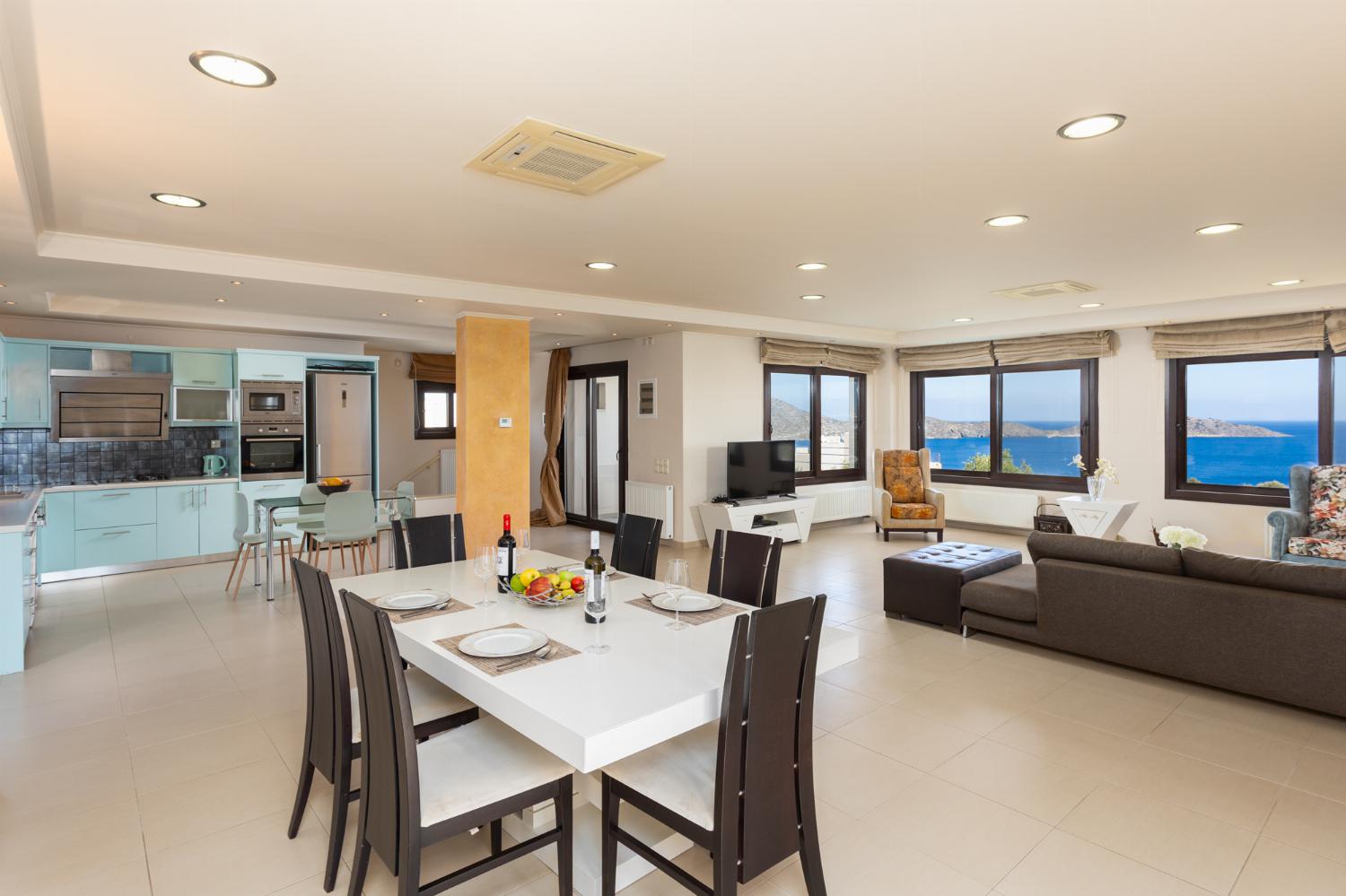 Open-plan living room with sofas, dining area, kitchen, A/C, WiFi internet, satellite TV, and panoramic sea views
