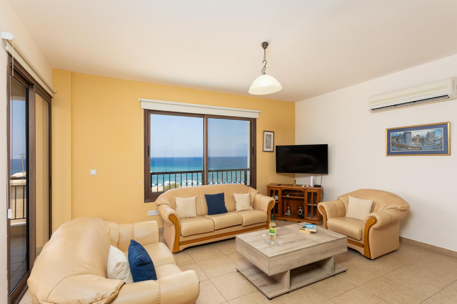 Open-plan living room with sofas, dining area, kitchen, A/C, WiFi internet, satellite TV, and sea views