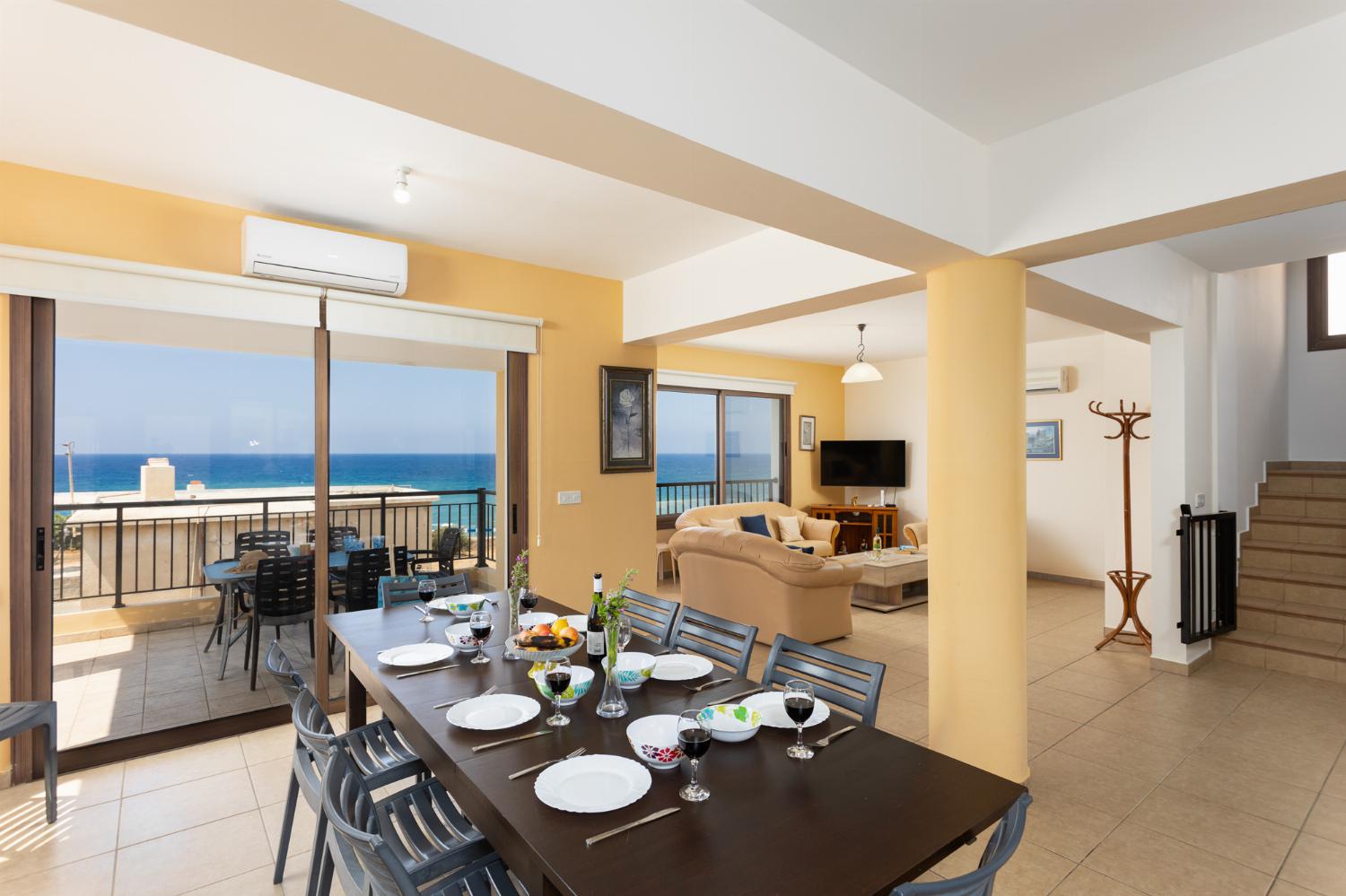 Open-plan living room with sofas, dining area, kitchen, A/C, WiFi internet, satellite TV, and sea views
