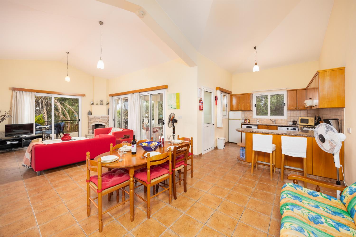 Open-plan living room with sofas, dining area, kitchen, ornamental fireplace, WiFi internet, and satellite TV