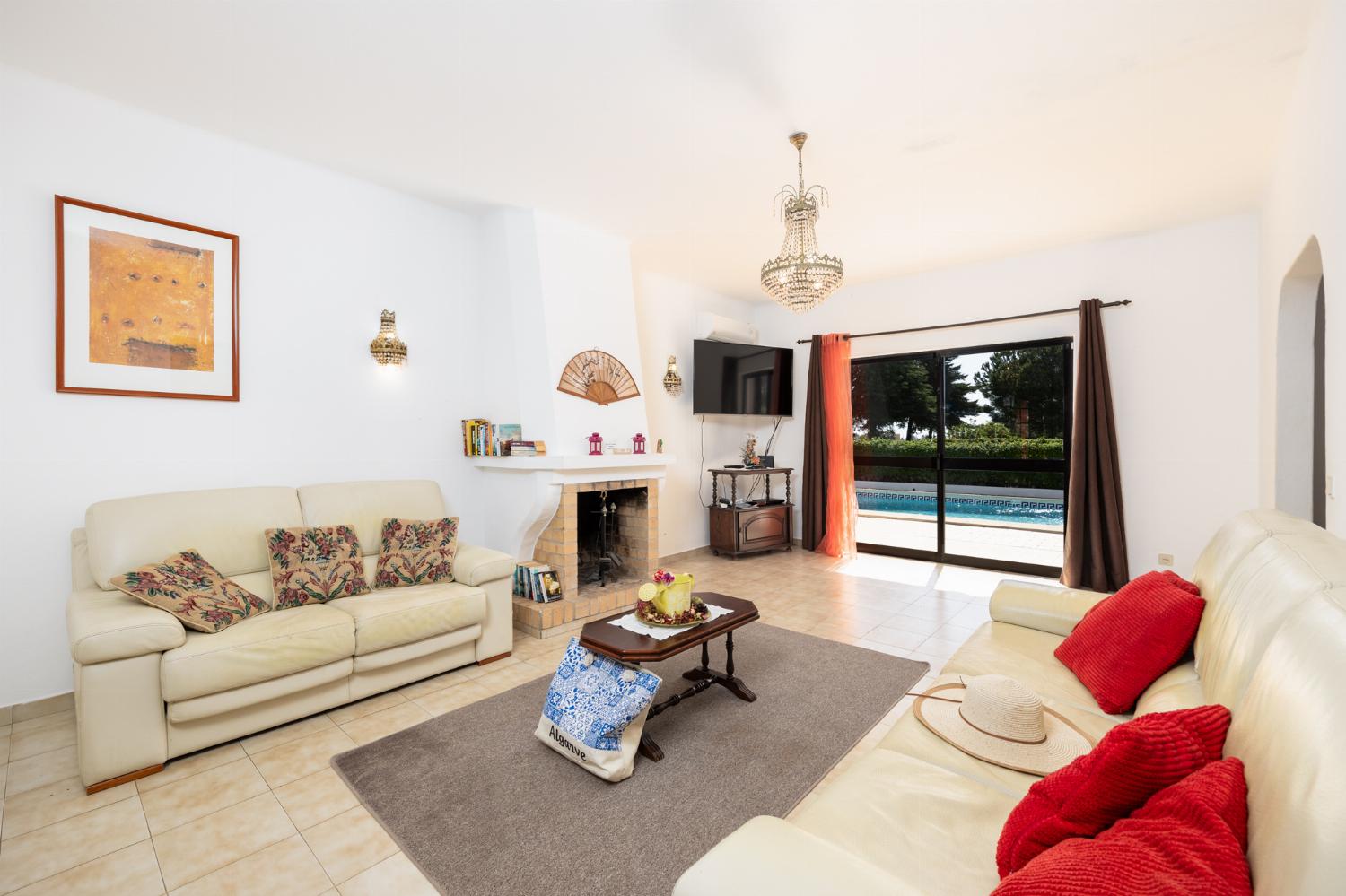 Living room with sofas, ornamental fireplace, A/C, WiFi internet, and satellite TV