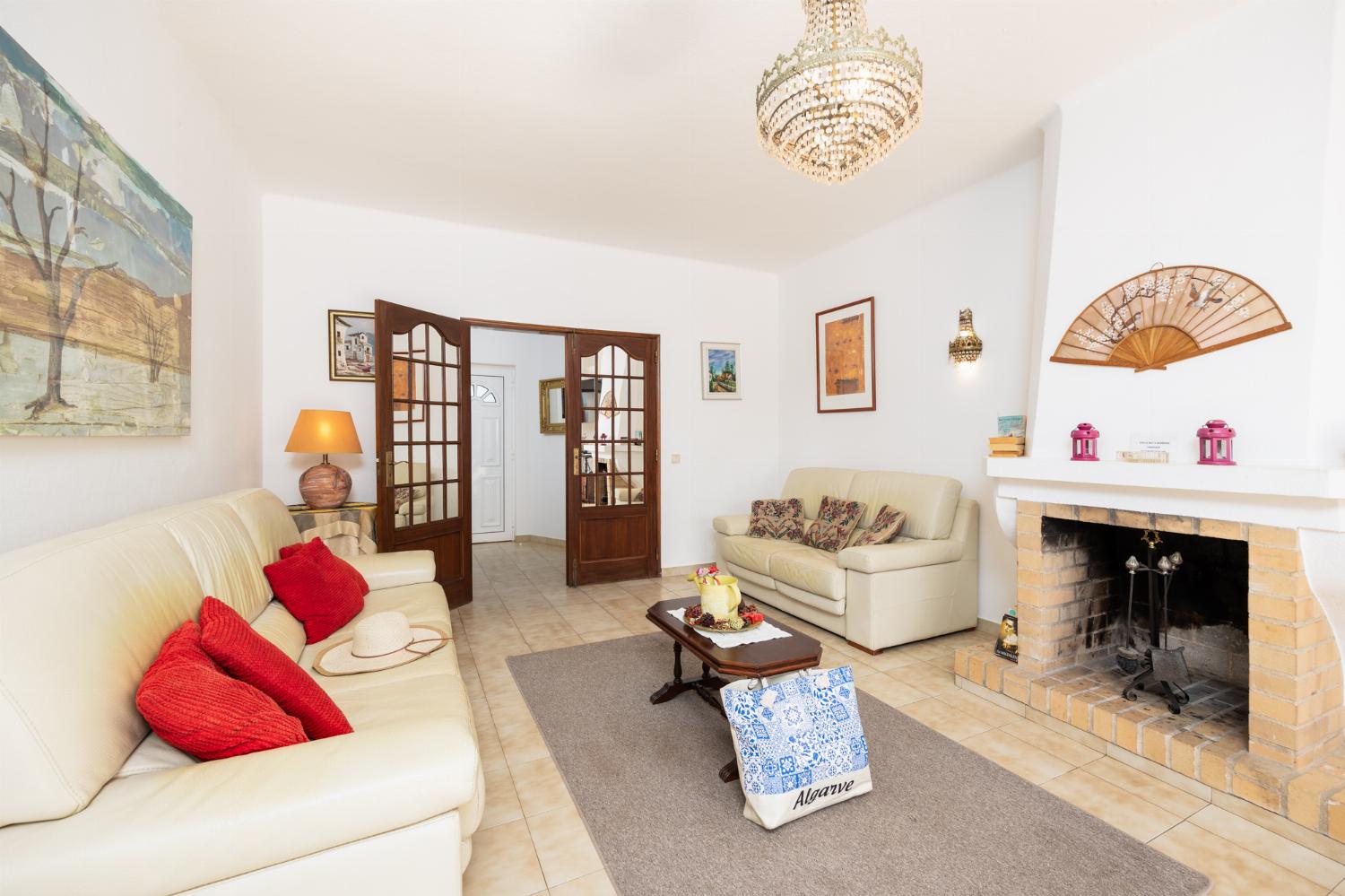 Living room with sofas, ornamental fireplace, A/C, WiFi internet, and satellite TV