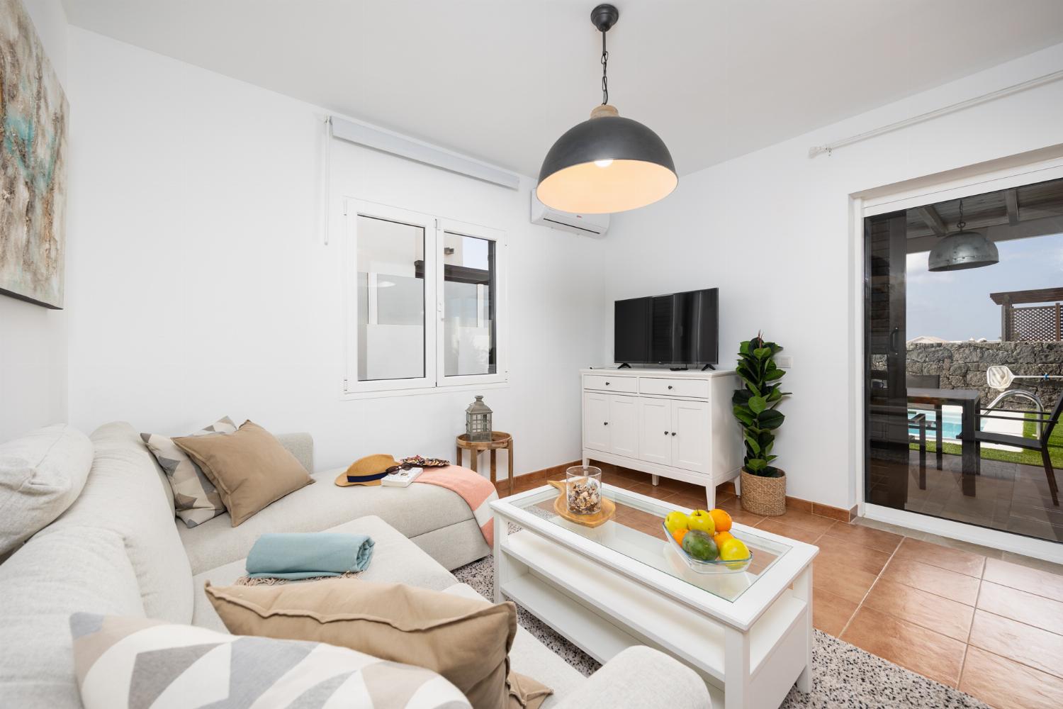 Living room with sofa, dining area, A/C, WiFi internet, and satellite TV