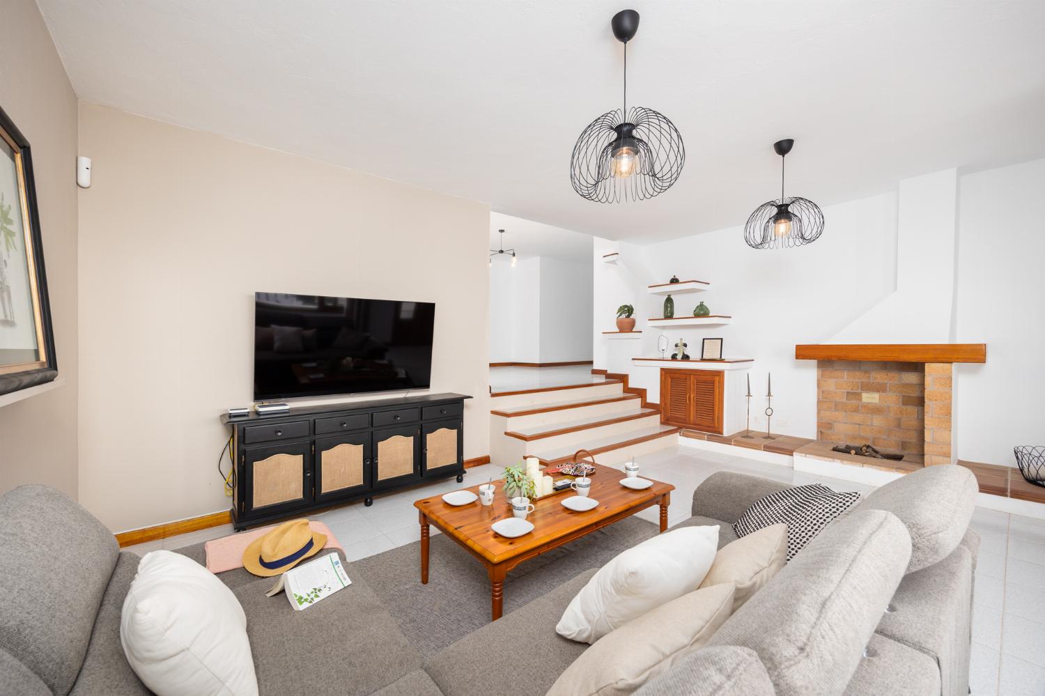 Living room with sofa, ornamental fireplace, A/C, WiFi internet, and satellite TV