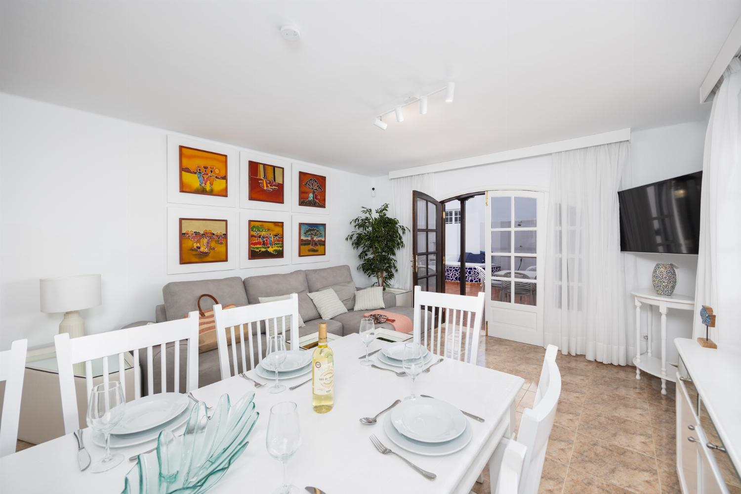 Living room with sofas, dining area, A/C, WiFi internet, and satellite TV